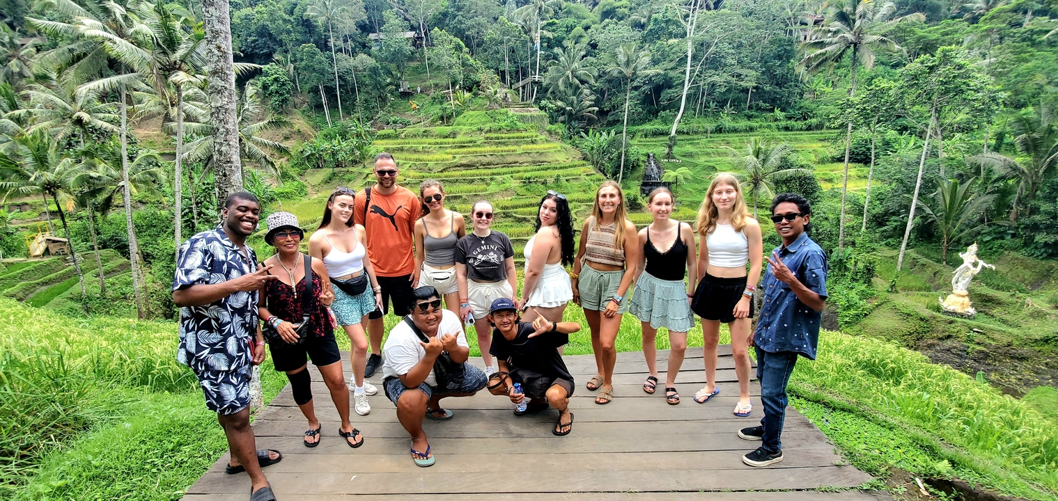Group enjoying a green terraced landscape, posing for the camera.