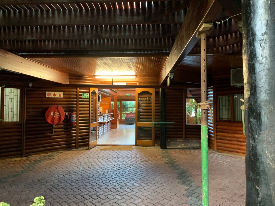 Interior of a wooden lodge with cobblestone flooring.