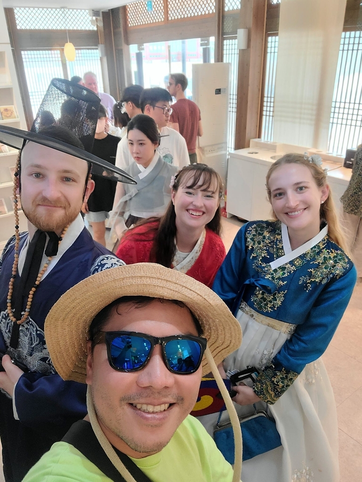 Des personnes posant en tenues coréennes traditionnelles à l'intérieur.