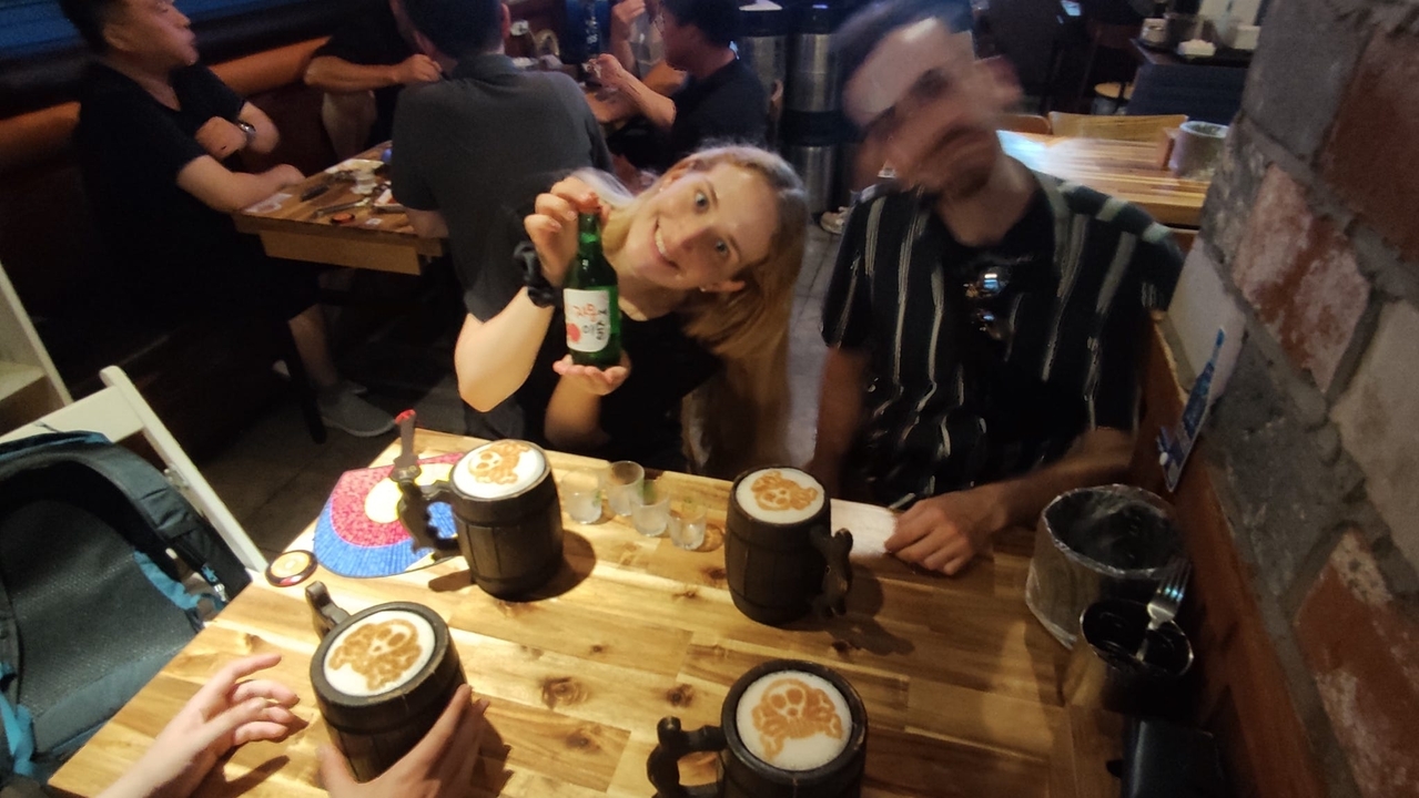 Des personnes à une table avec des boissons et de la nourriture à l'intérieur.