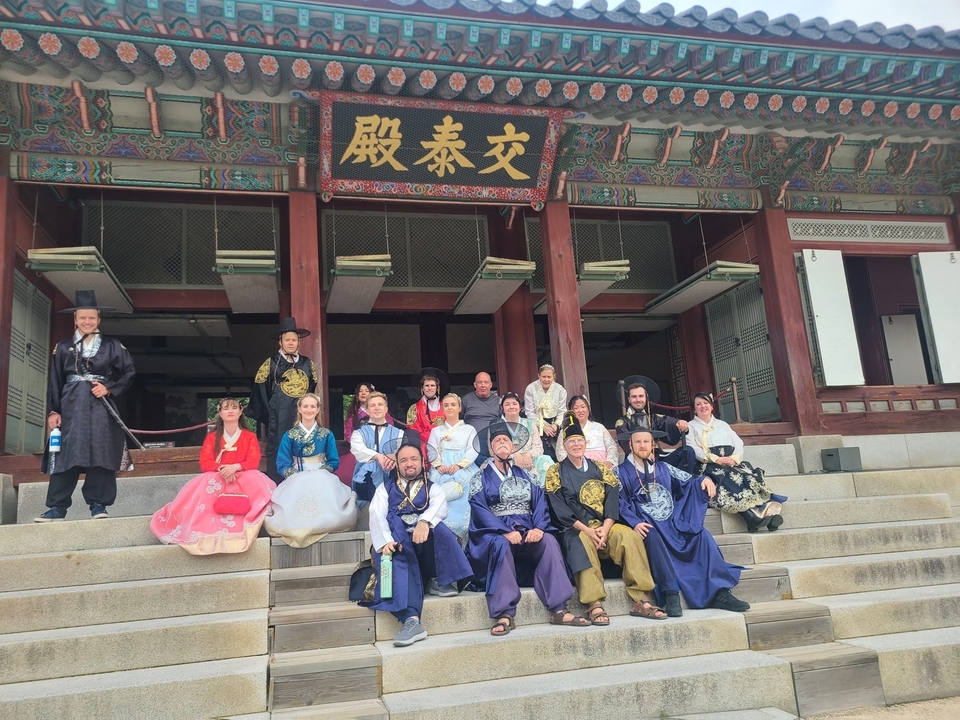 Groupe de personnes en tenues traditionnelles sur un site historique.