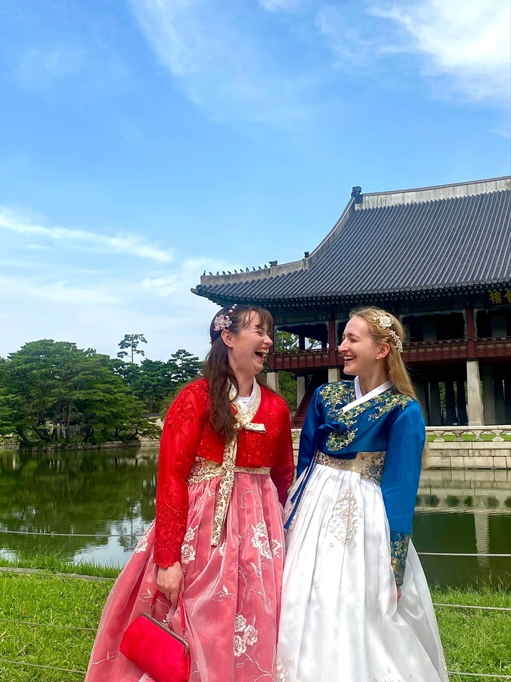 Deux femmes en vêtements traditionnels devant un bâtiment historique.