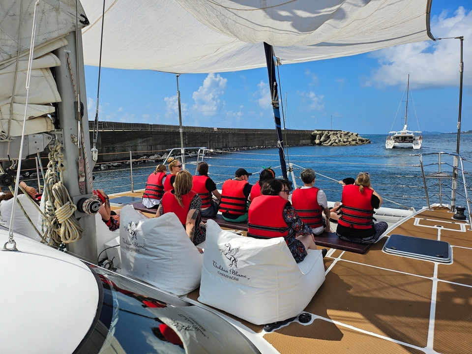Un groupe de personnes portant des gilets de sauvetage sur un bateau.