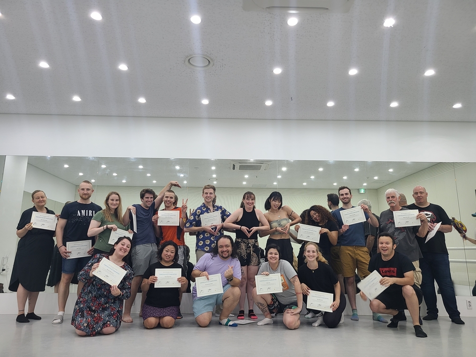 Groep houdt certificaten vast, poserend binnenshuis.