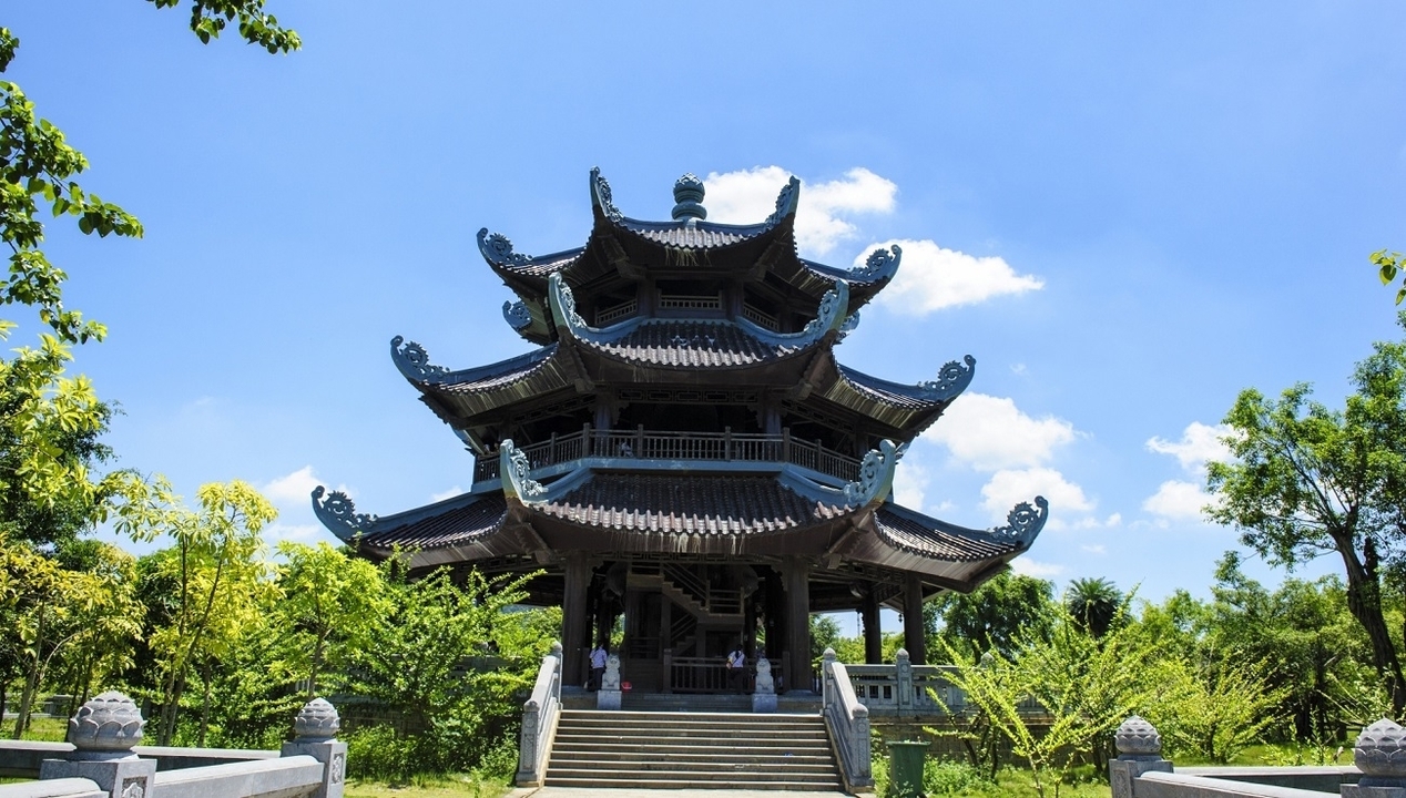 Pagoda surrounded by greenery under a clear sky.