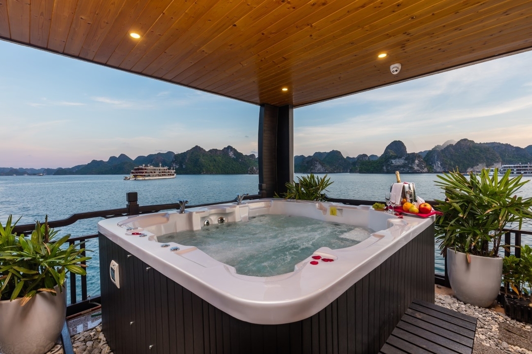 Jacuzzi sur un pont de croisière avec vue sur des montagnes karstiques en arrière-plan.