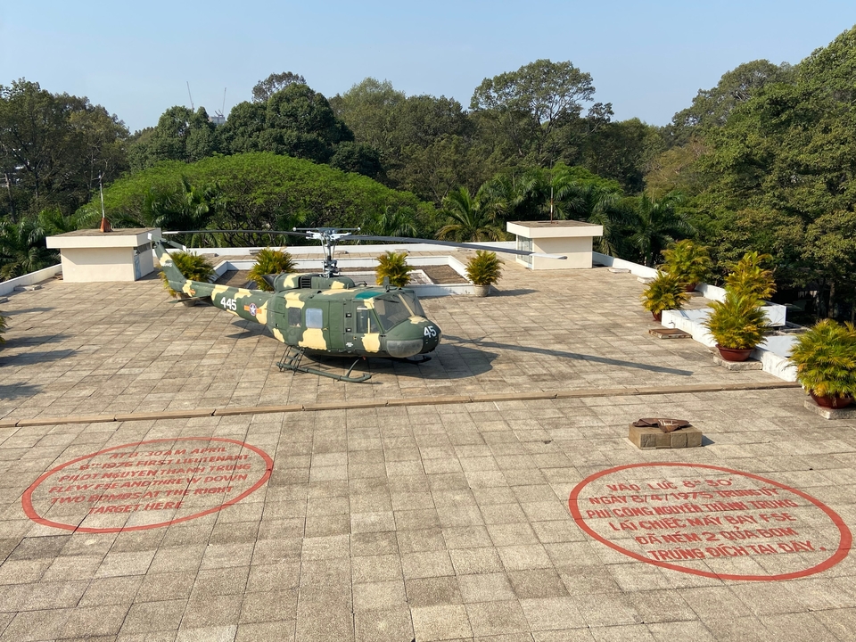 Hélicoptère sur un toit entouré d'arbres.