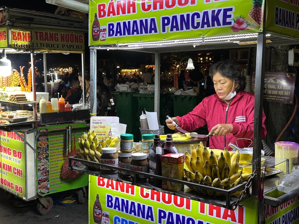 Street food vendor preparing dishes at a night market.