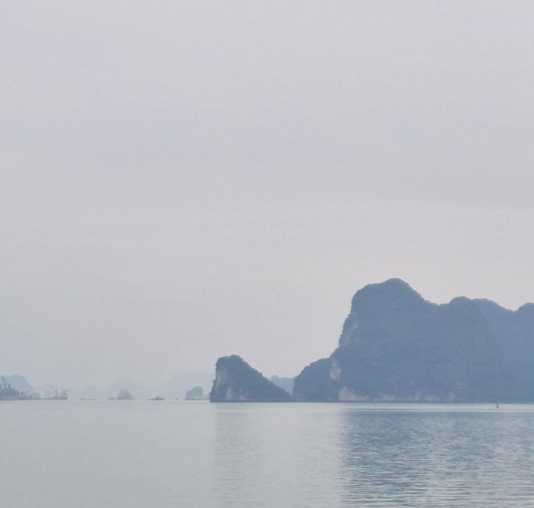 Silhouette of karst mountains under cloudy sky.