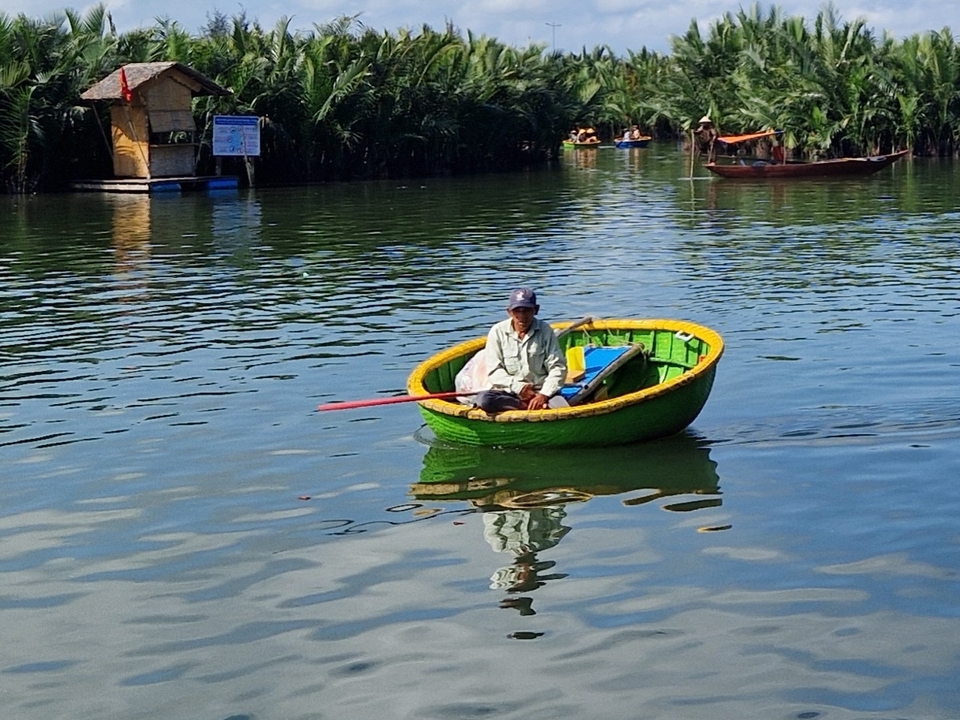 Person in a round boat on river with trees.