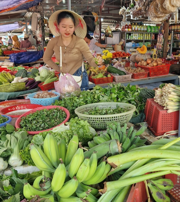 Market with fresh vegetables and shopper.