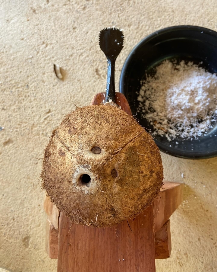 Gros plan d'une noix de coco en train d'être râpée.