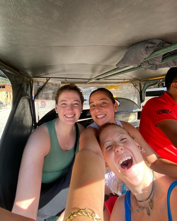 Trois personnes souriantes à l'intérieur d'un véhicule.