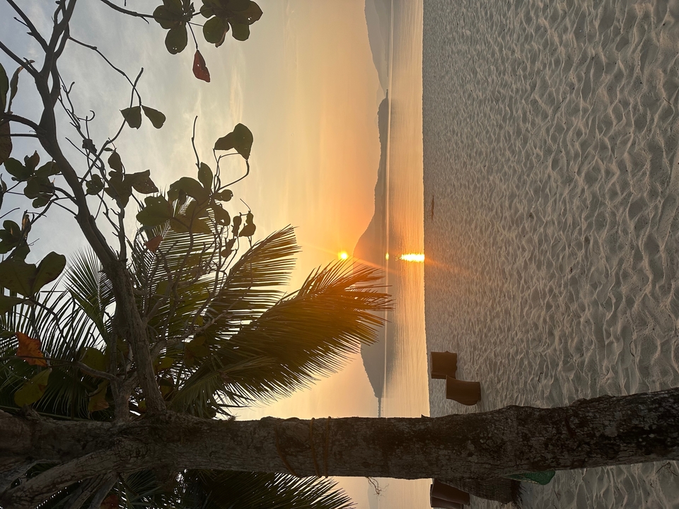 Coucher de soleil sur la mer avec plage au premier plan.