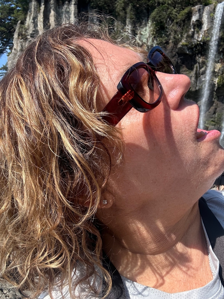 Gros plan d'une personne avec des lunettes de soleil et des cheveux blonds.