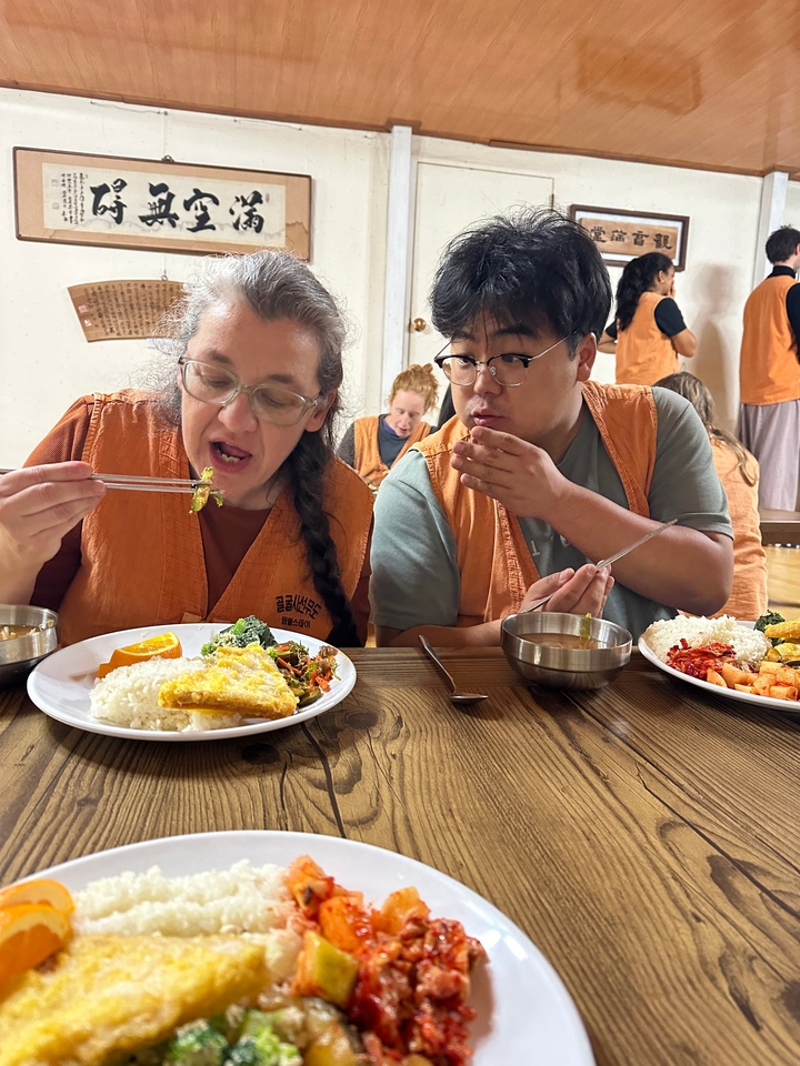 Deux personnes savourant de la nourriture coréenne traditionnelle à l'intérieur d'un restaurant.