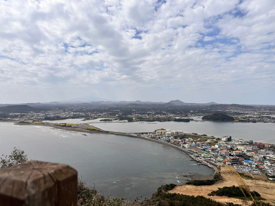 Vue panoramique d'une ville côtière avec des montagnes en arrière-plan.