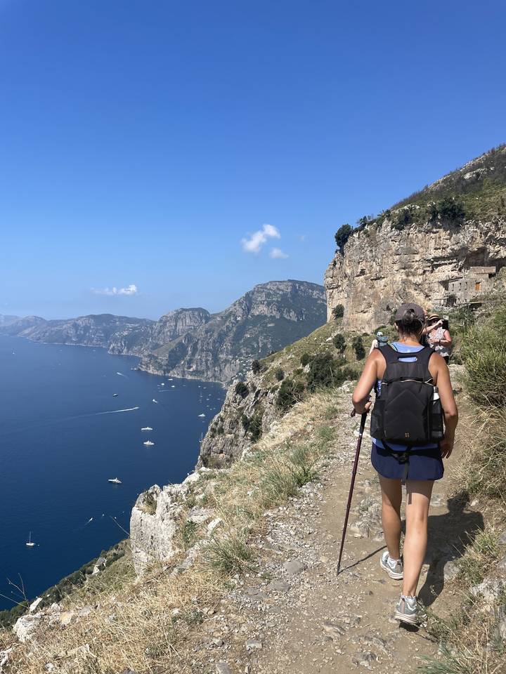 Hiker on a cliffside trail overlooking the sea