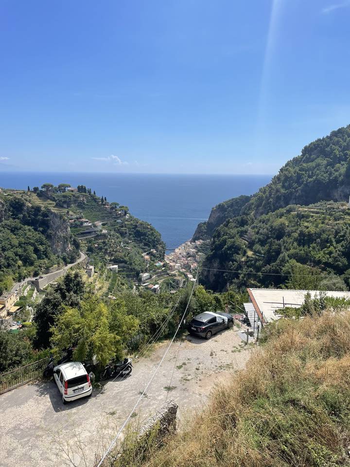 Cars parked on a hill with a view of the sea