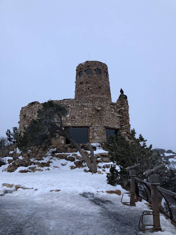Stone building with a snowy landscape in the background.