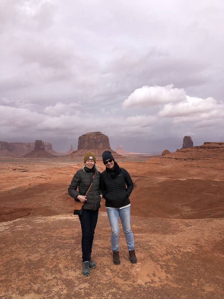 Two people standing on a vast desert landscape.