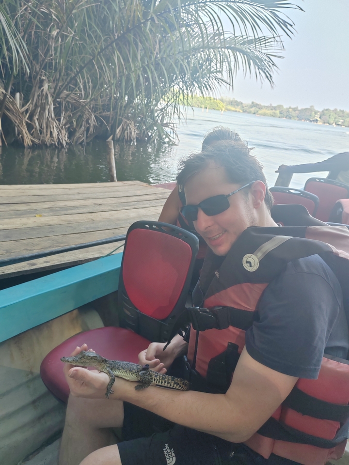 Personne souriante sur un quai au bord de l'eau.