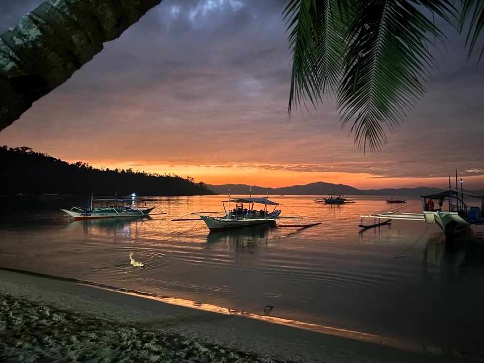 Coucher de soleil sur une baie avec des bateaux.
