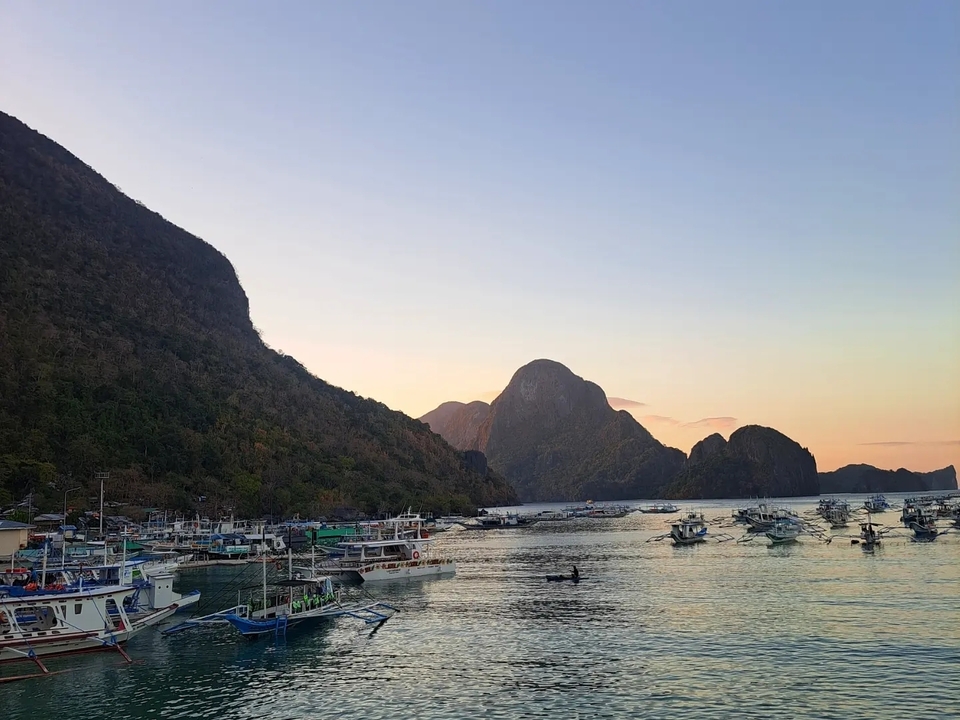 Bateaux dans une baie au coucher du soleil.