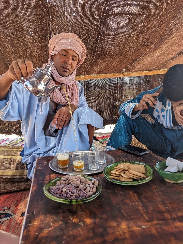 Deux hommes en tenue traditionnelle versant du thé.