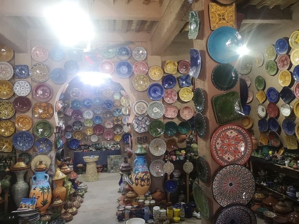 Pièce avec poterie marocaine traditionnelle et assiettes décoratives.