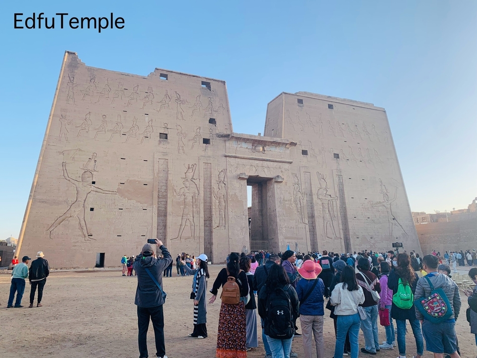 Large group of tourists in front of a historic temple.
