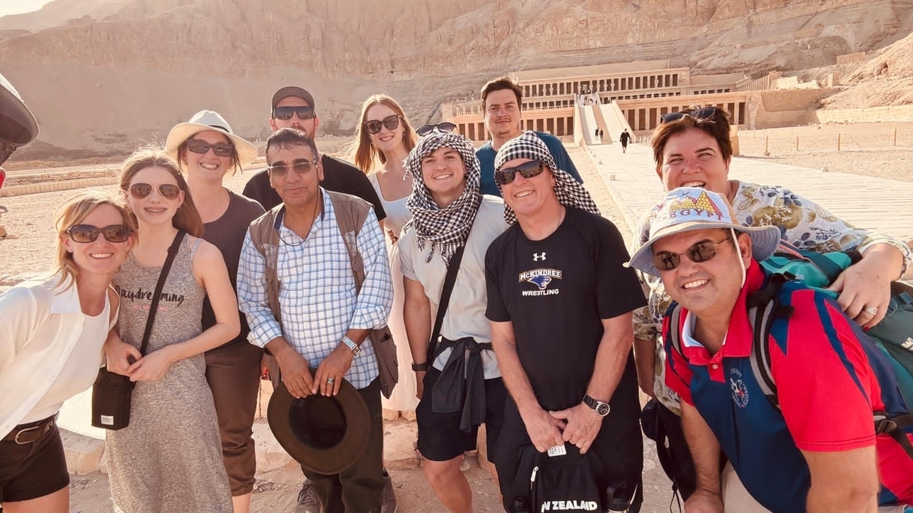 Group of tourists posing in front of an ancient temple.