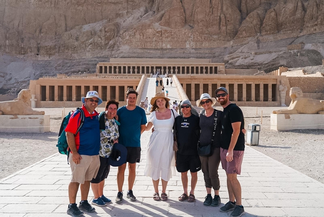 Group of people posing in front of an ancient temple.