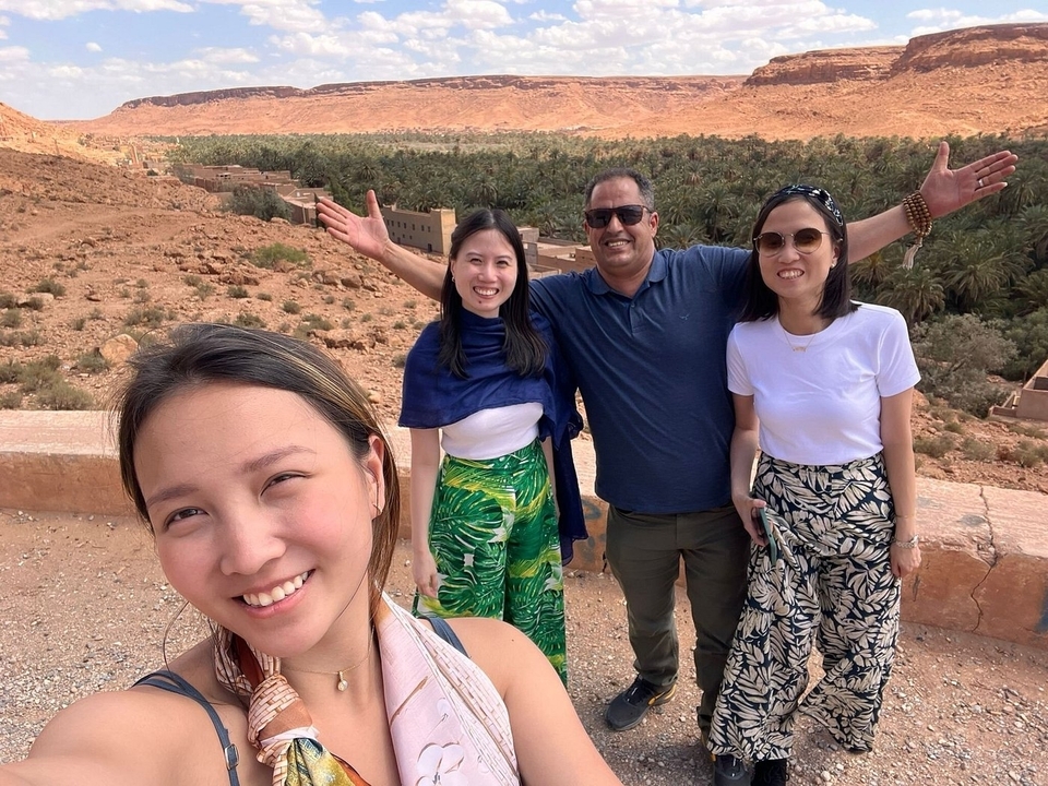 Groupe de personnes souriantes qui prennent la pose dans un décor désertique.