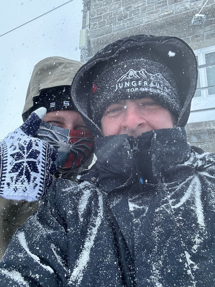 Deux personnes habillées chaudement dans des conditions neigeuses.