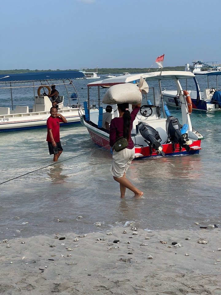 People unloading a boat on the beach.