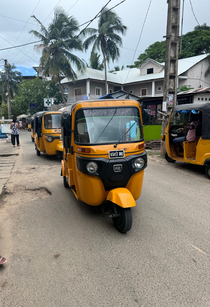 Yellow tuk-tuks on a city street.