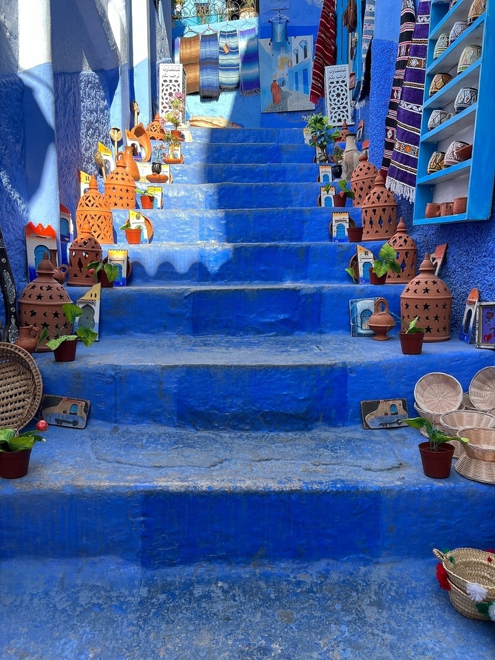 Blue painted stairs with pots and decorations.