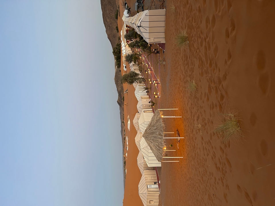 Camp du désert avec des tentes au crépuscule.