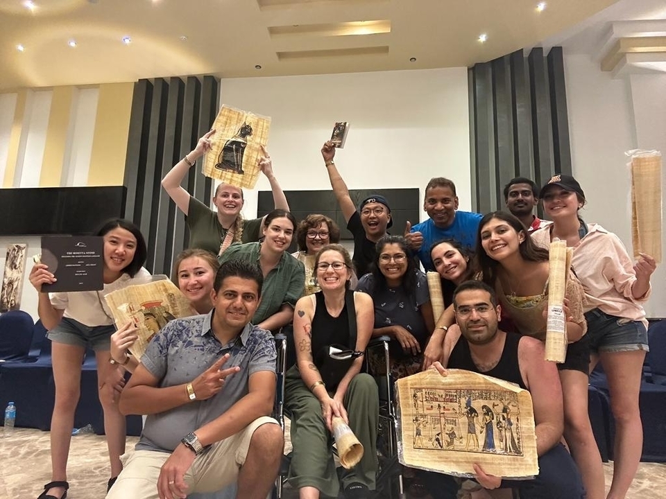 Un groupe de personnes tenant des souvenirs et posant à l'intérieur.