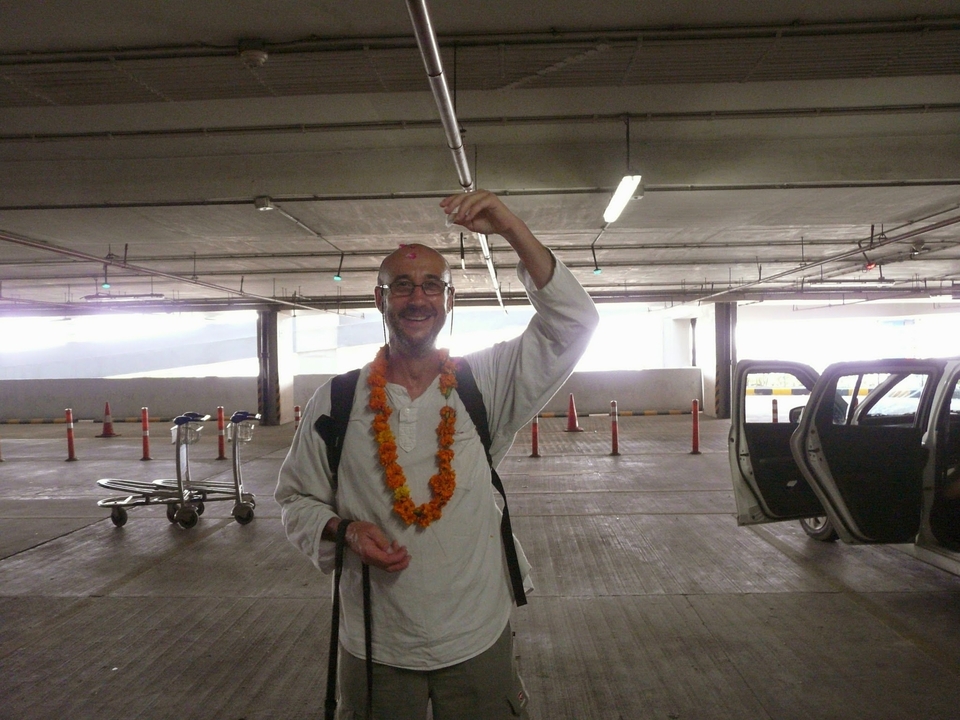 Personne avec une guirlande posant dans une zone de stationnement.