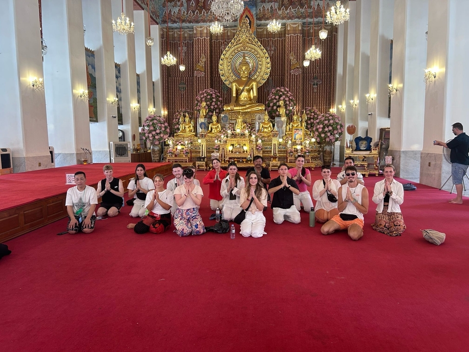 Large group meditating in a golden temple.