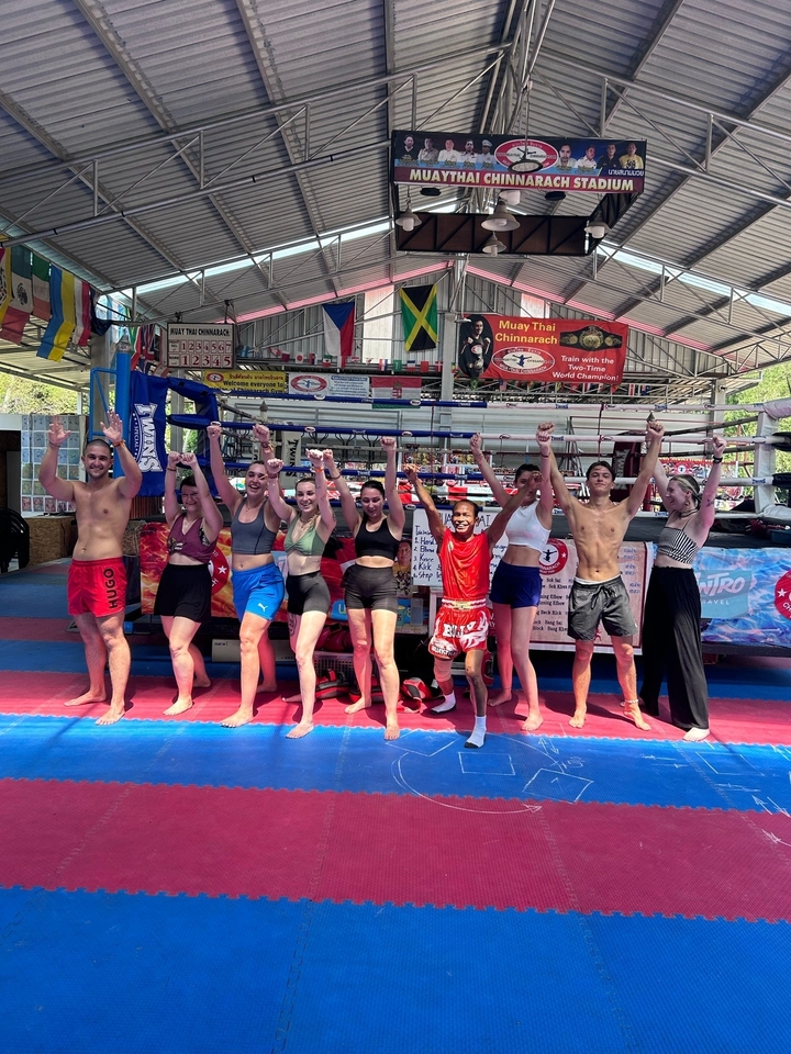 Group of people posing in a Muay Thai gym.