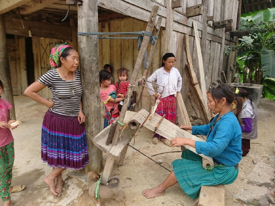 Un groupe de femmes travaillant ensemble avec des outils traditionnels dans un cadre rural.