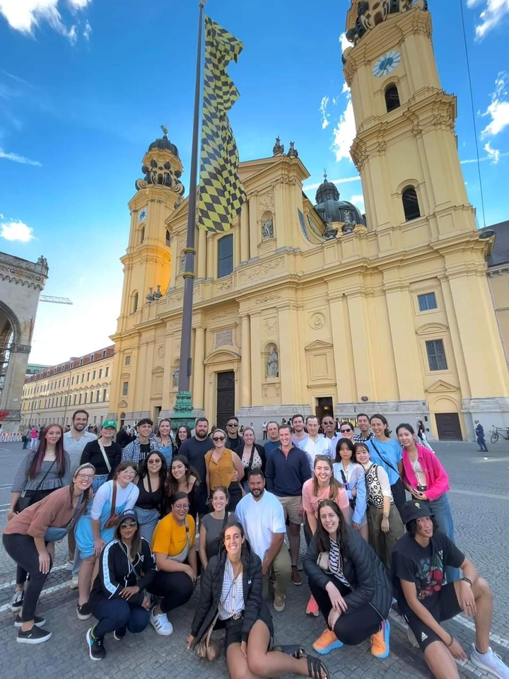 Large group in front of a historic building in a city.