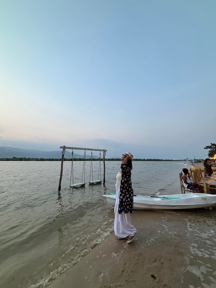 Woman by a lakeside with swings.