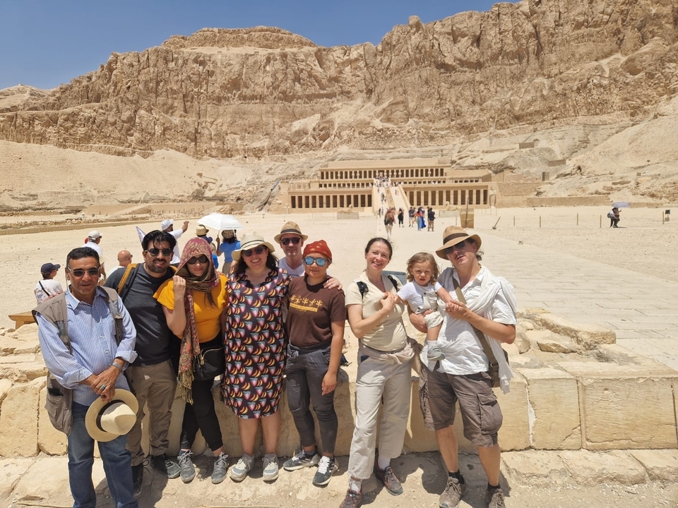 Group of people posing in front of ancient Egyptian temple.