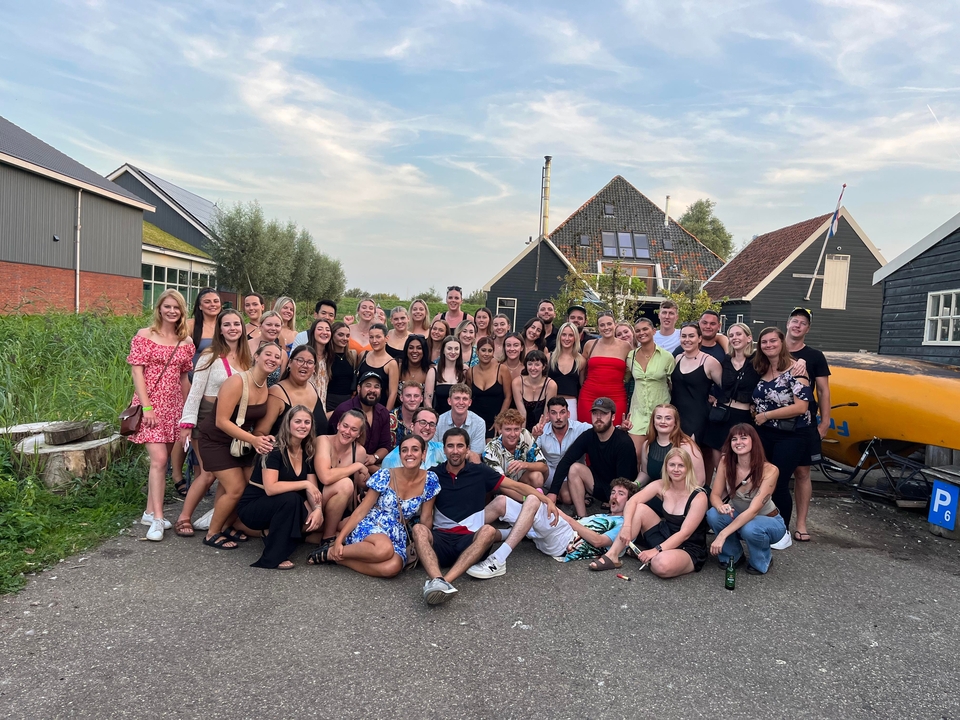 Large group of people gathered outside, posing for a photo.