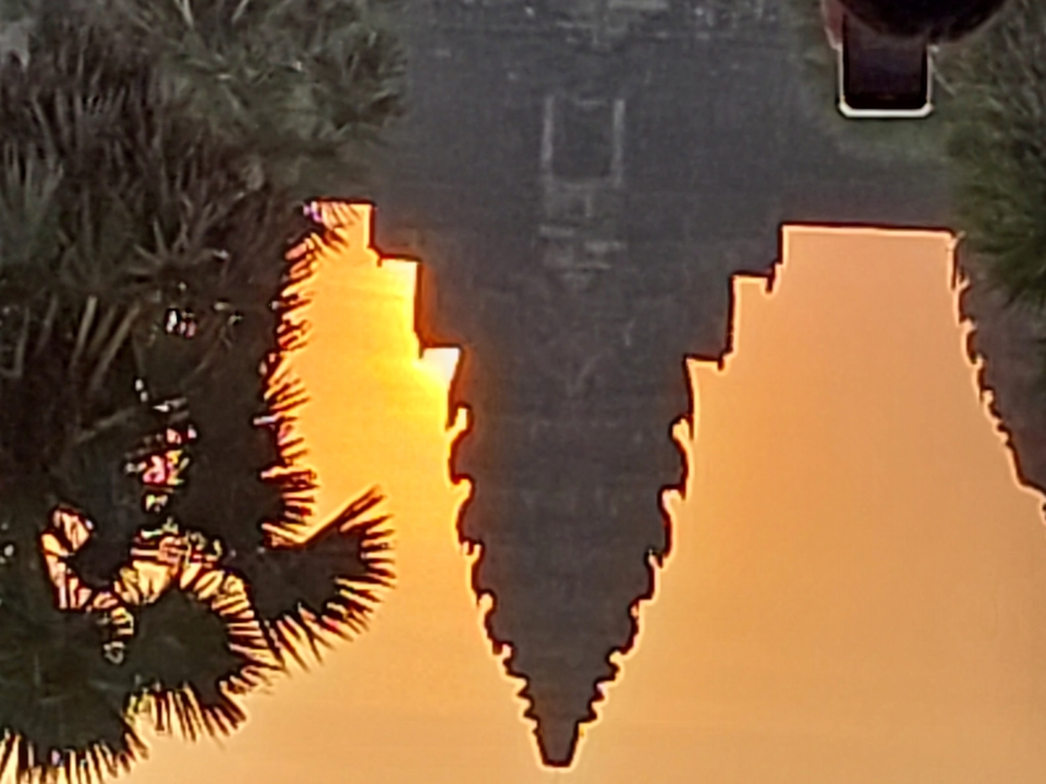 Blurry photo of temple with a sunset in the background.
