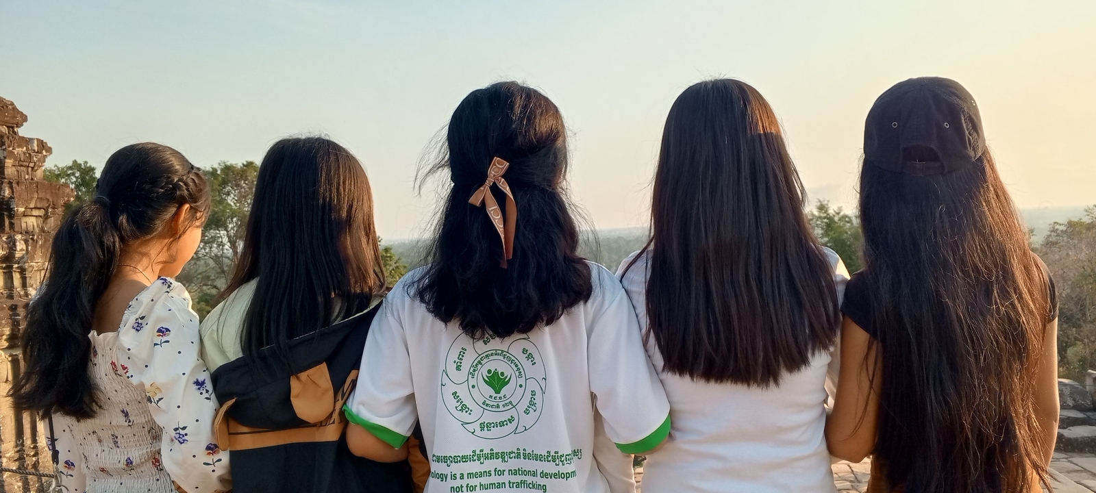 Group of people seen from behind during daylight.